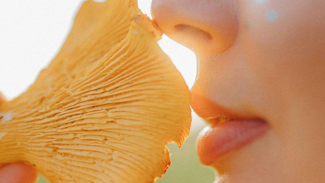 Woman smelling a mushroom
