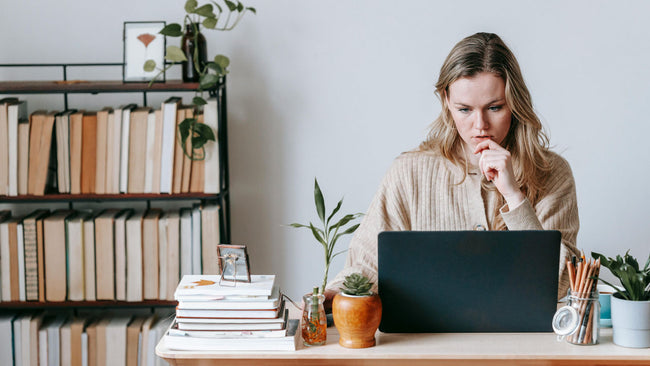 Woman concentrating while working on a laptop at a desk