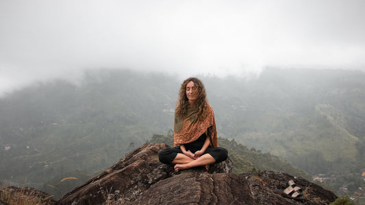 woman meditates on a mountain peak