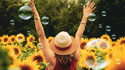 Woman with outstretched arms in a field of sunflowers