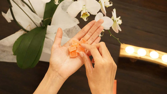 a person with orange gummies in hand