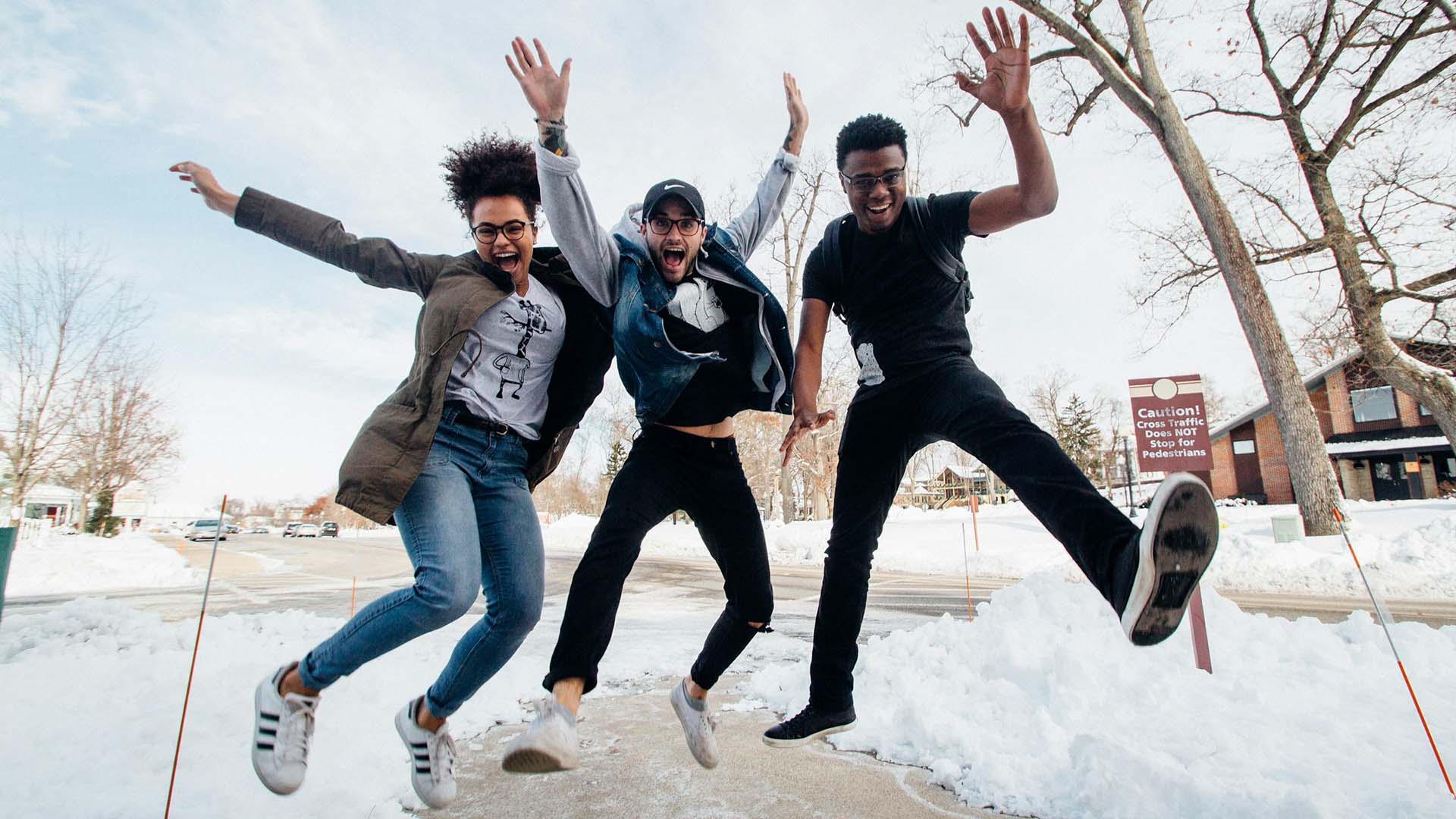 three friends having fun while jumping on the street