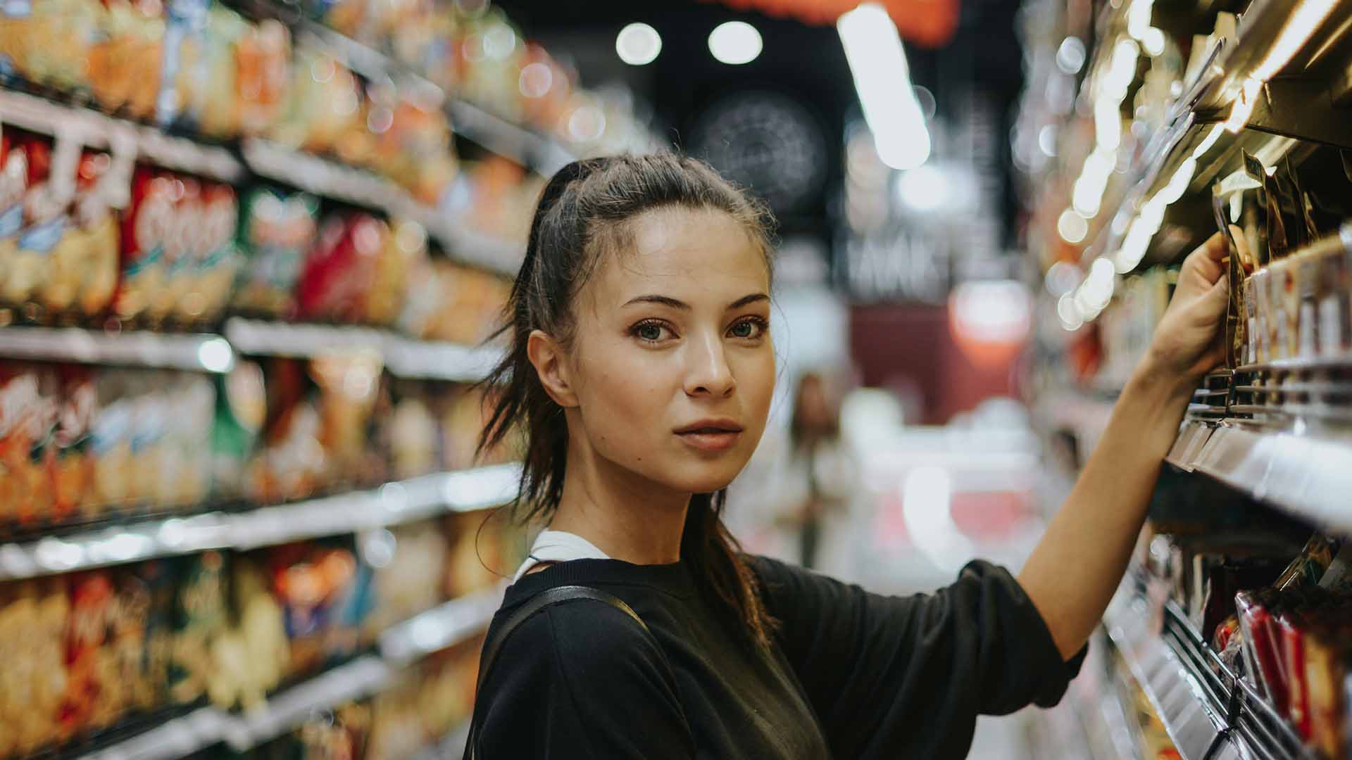 Woman selecting a product from a store shelf