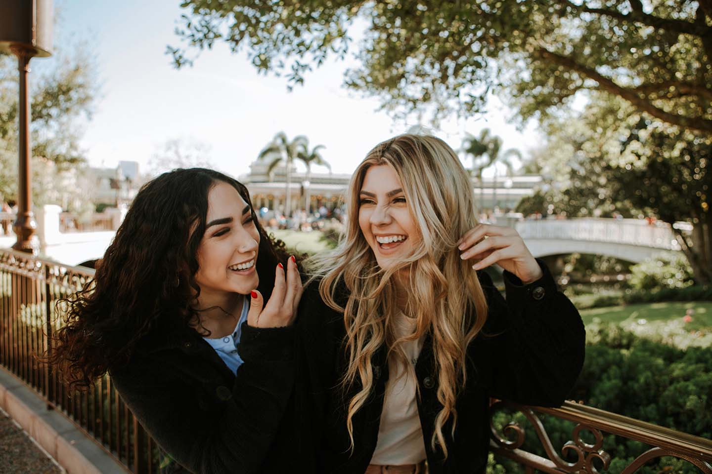 two women standing outside talking and laughing