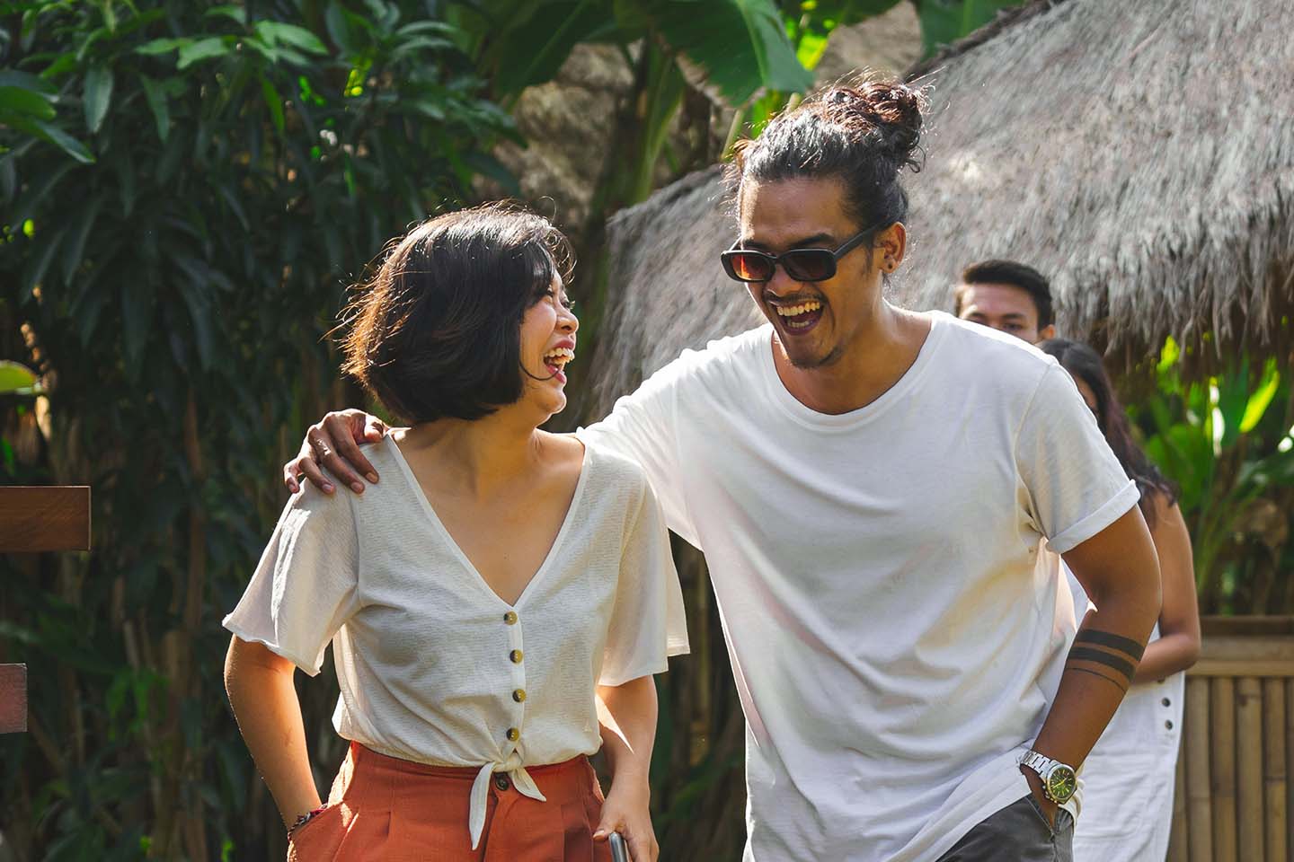 man and woman wearing white shirts walking outside and smiling