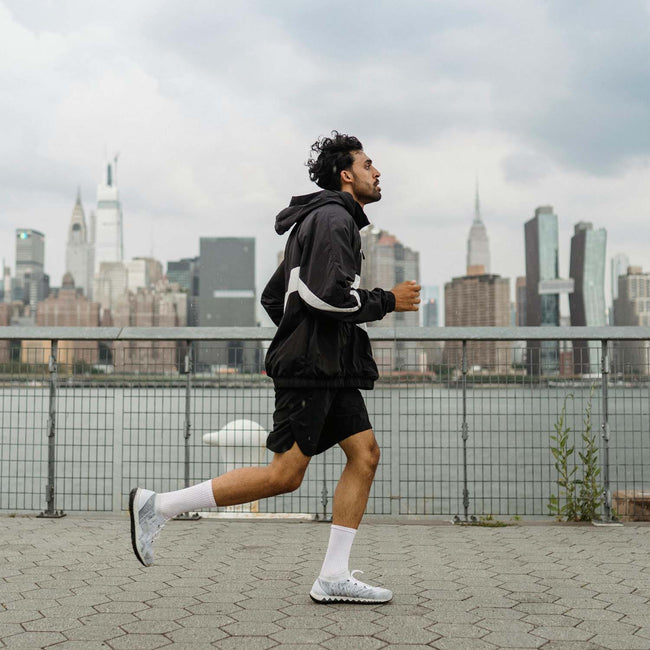 man running outside with city skyline background